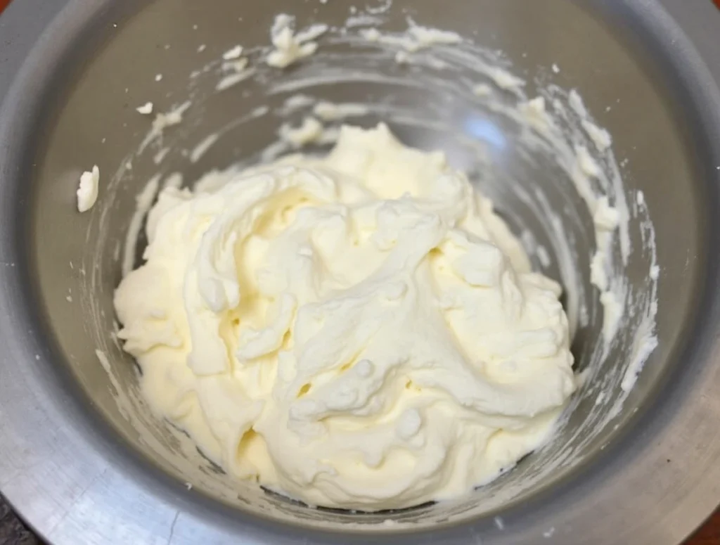 Step-by-step preparation of M&Ms Cool Whip Pudding Frosting on marble table