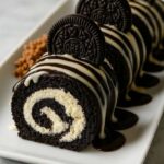 Close-up of sliced Oreo Cream Cheese Cheesecake Sushi Roll topped with white chocolate drizzle and whole Oreo cookies