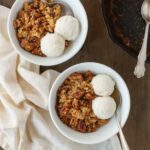 Close-up of pecan pie dump cake with vanilla ice cream served in white bowls