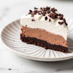 Gluten-Free Chocolate Mousse Cake topped with whipped cream and chocolate shavings
