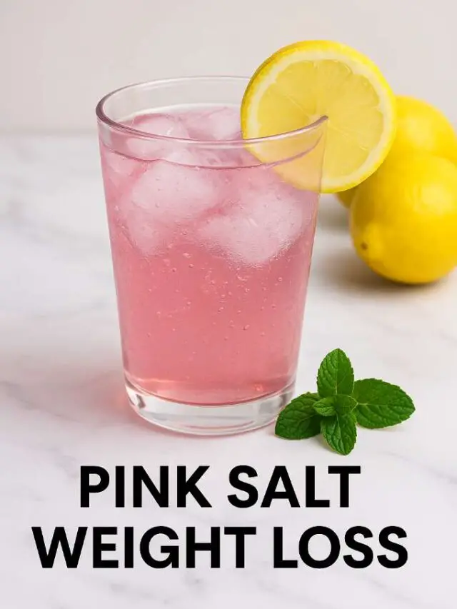 Glass of pink salt weight loss drink with lemon slice and mint on marble table