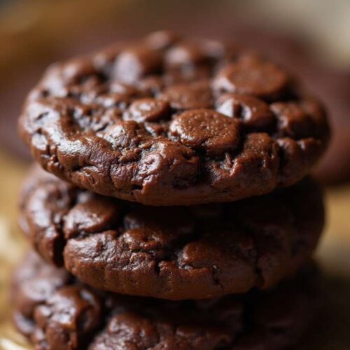 A batch of no-bake chocolate oat cookies on a white marble surface with rustic texture and glossy chocolate finish