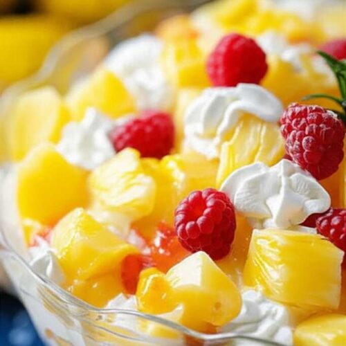 Creamy Pineapple Salad in a glass bowl, topped with a cherry, ready to be served.