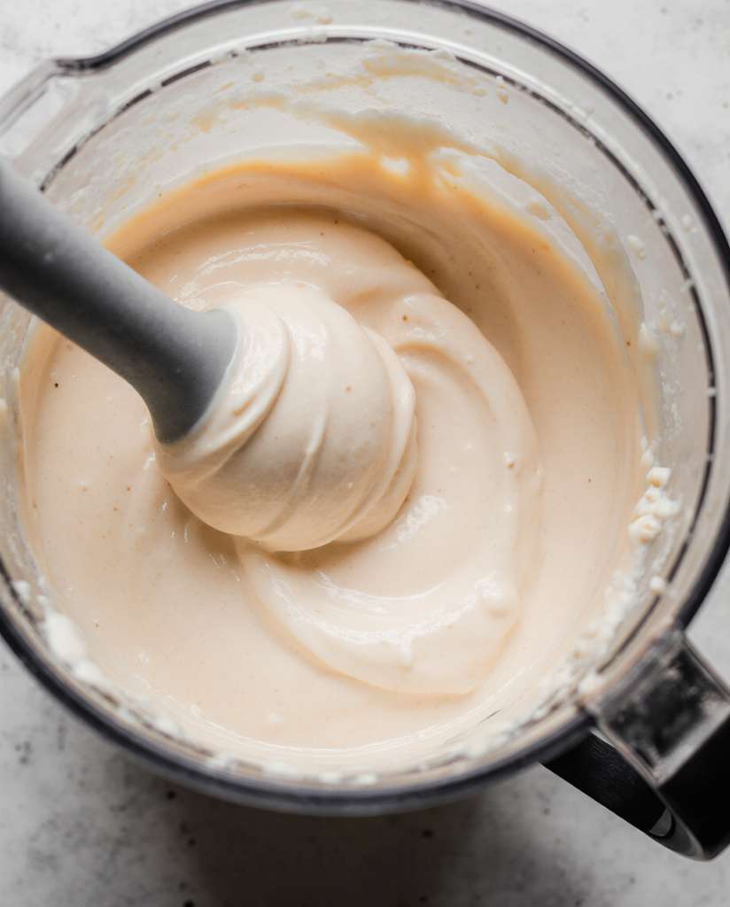 Creamy ice cream custard churning in a home maker, a key step in creating a homemade, gluten-free dessert.